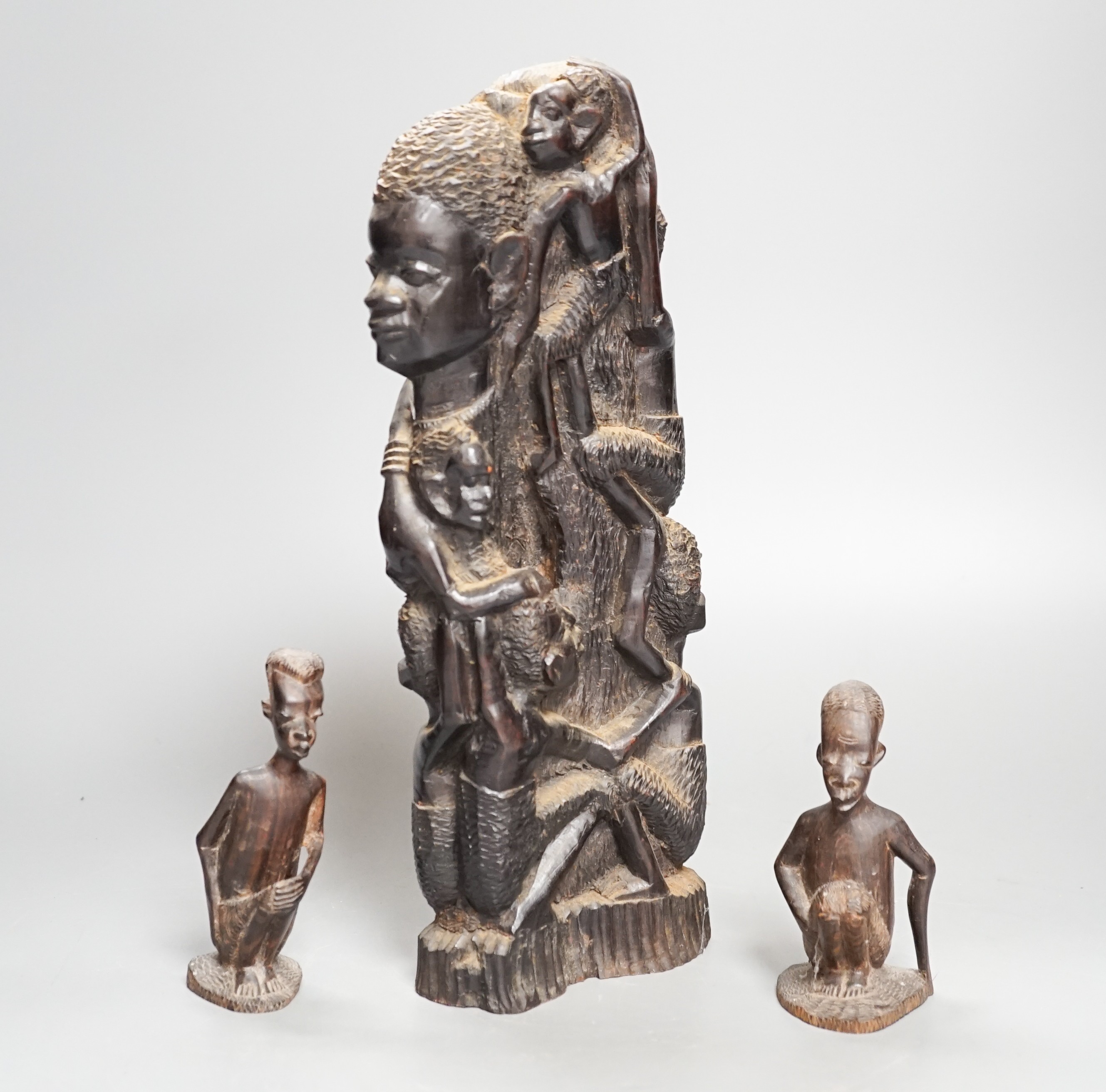 Four tribal hardwood carvings, two bows and two bronze spears longest 85cm